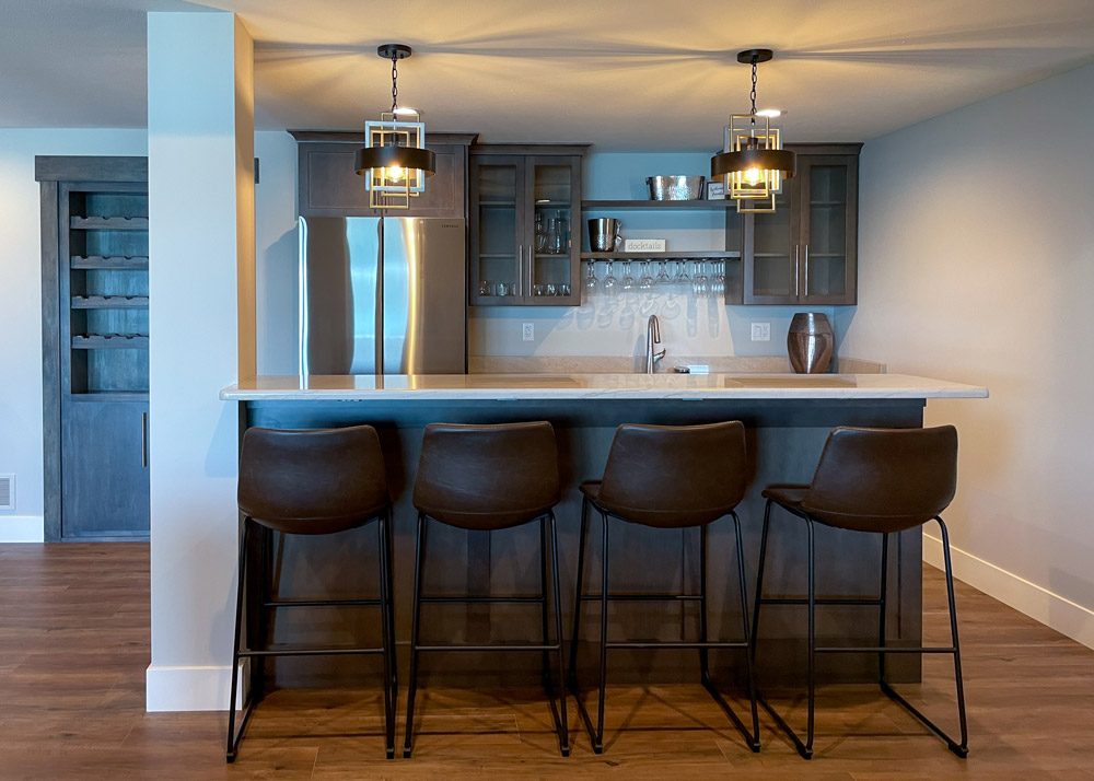Parade of Homes 2022's basement kitchen bar with pendant lights and bar stools