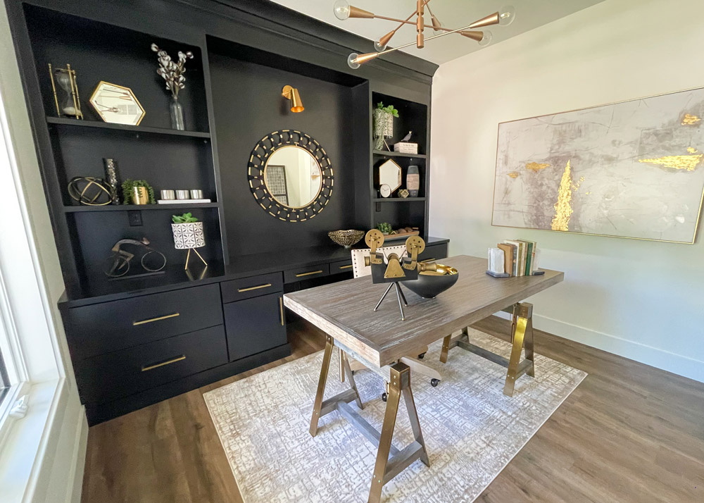 Parade of Homes 2022's office with black cabinetrs and gold artwork and accents